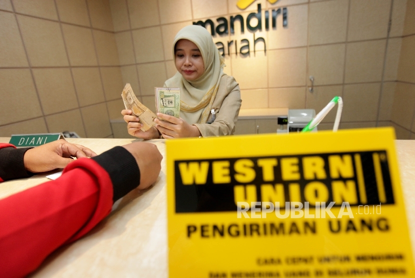 Pegawai Mandiri Syariah tengah melayani nasabah yang melakukan transfer dana ke luar negeri di Bank Mandiri Syariah Cabang Menteng, Jakarta, Selasa (12/9).