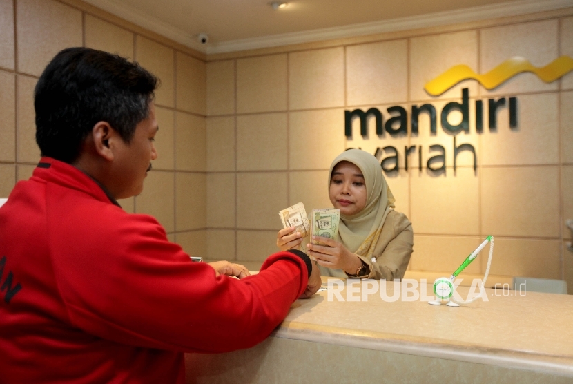 Pegawai Mandiri Syariah tengah melayani nasabah yang melakukan transfer dana ke luar negeri di Bank Mandiri Syariah Cabang Menteng, Jakarta, Selasa (12/9).
