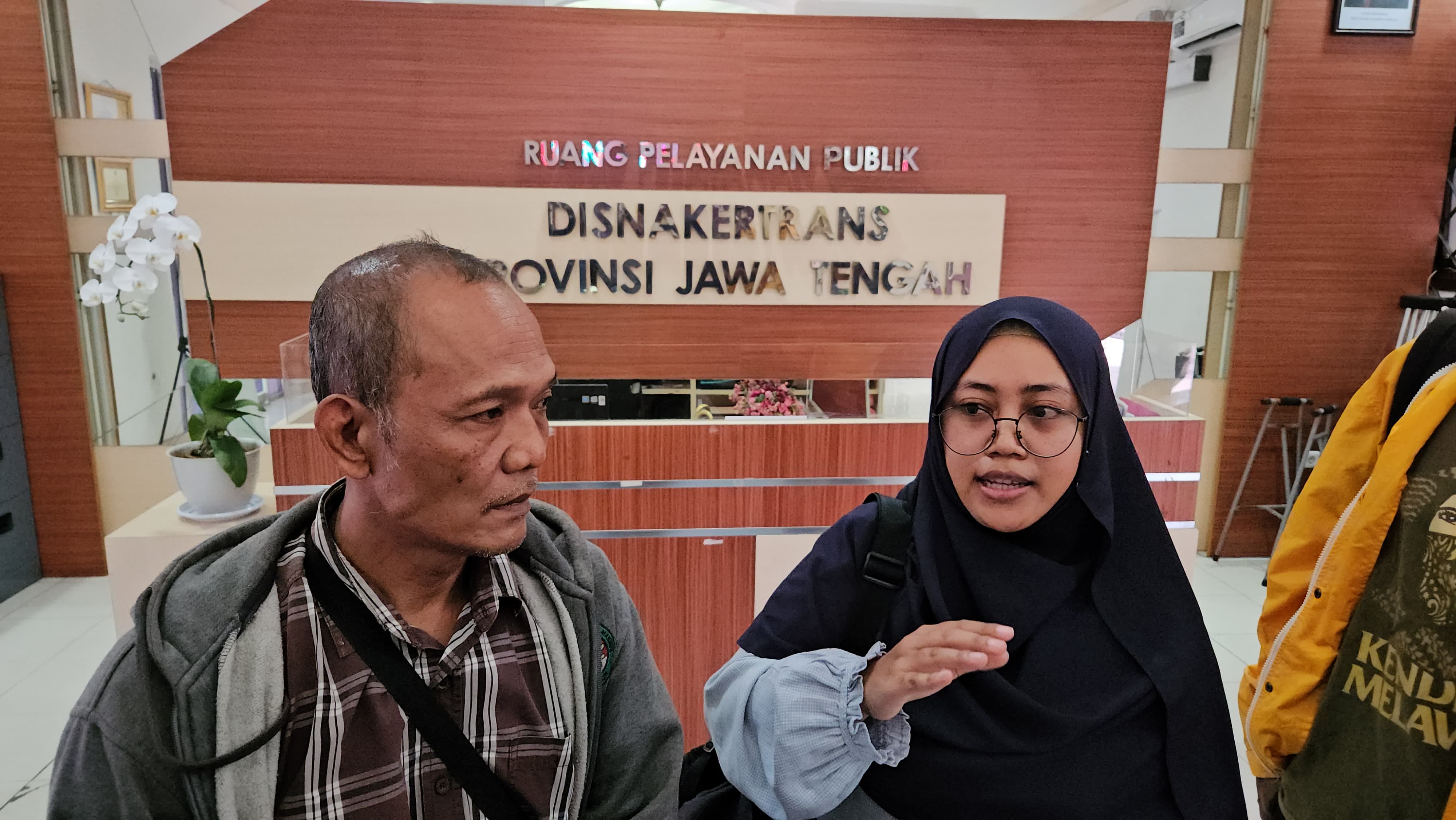 Pegawai media Suara Merdeka, Sumarlan (kiri), dan perwakilan Lembaga Bantuan Hukum (LBH) Semarang, Amadela Andra Dynalaida, memberikan keterangan kepada awak media di Kantor Dinas Ketenagakerjaan dan Transmigrasi (Disnakertrans) Provinsi Jawa Tengah (Jateng), Kota Semarang, Senin (28/7/2025). Lima pegawai Suara Merdeka melaporkan perusahaan pers tersebut karena tak membayarkan gaji selama berbulan-bulan. 