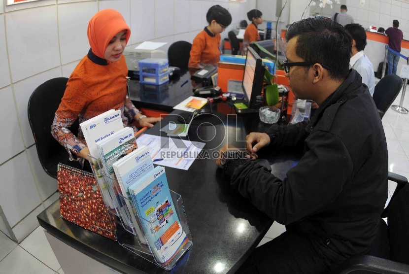  Pegawai melayani nasabah di banking hall Bank BRI, Jakarta, Selasa (15/9).