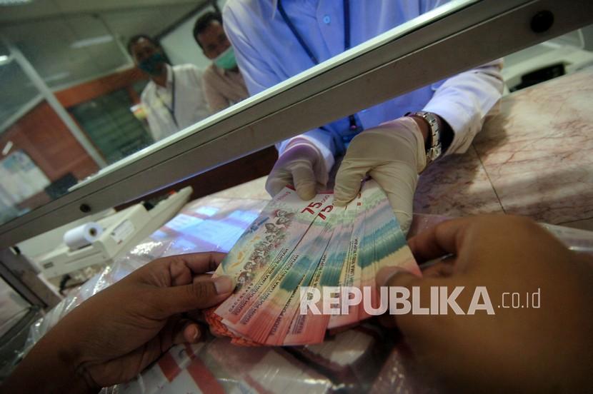 Pegawai melayani penukaran uang baru pecahan Rp75.000 di Kantor Perwakilan (Kpw) Bank Indonesia (BI), Tegal, Jawa Tengah, Kamis (22/4/2021). Menurut Kpw BI Tegal, untuk memastikan kualitas layak edar dan perluasan penukaran Uang Peringatan Kemerdekaan 75 Tahun RI (UPK 75) pecahan Rp75.000 dalam bertransaksi selama Ramadhan dan Idul Fitri 1442 H, masyarakat dapat menukar satu KTP untuk 100 lembar UPK 75 setiap harinya dan dapat diulang pada hari berikutnya. 