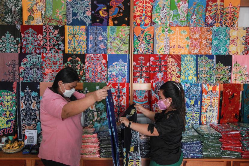 Pegawai menata kain batik motif khas Kalimantan Tengah yang dijual di Toko Moneng Galeri, Palangka Raya, Kalimantan Tengah, Kamis (27/10/2022). Pengembangan bisnis UMKM lokal dinilai perlu didukung dengan masifnya kemajuan teknologi.