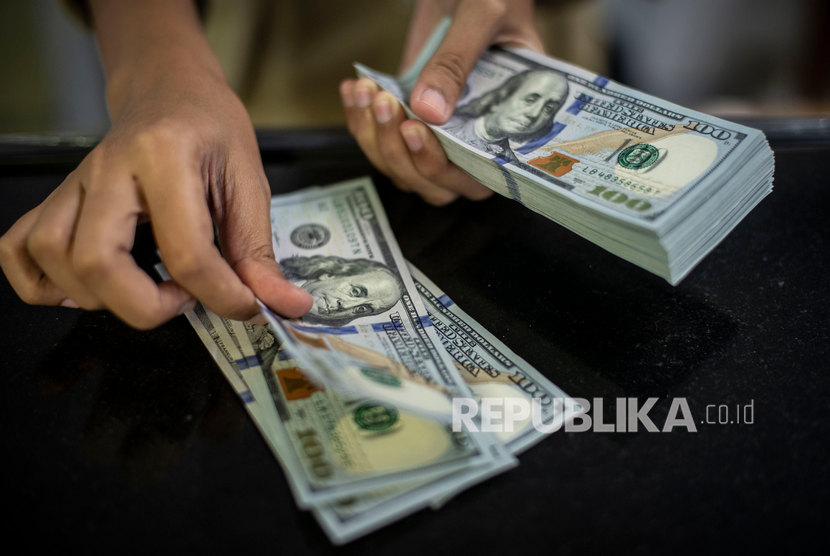 Pegawai menghitung uang dolar Amerika Serikat (AS) di gerai penukaran mata uang asing PT Ayu Masagung, Jakarta, Rabu (4/3). Dolar Amerika Serikat (AS) stabil pada akhir perdagangan Senin (25/10), setelah melonjak dari level terendah satu bulan.