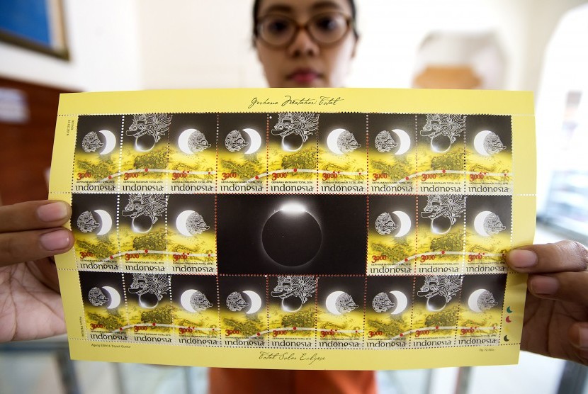 Pegawai menunjukkan prangko edisi Gerhana Matahari Total di Kantor FIlateli, Jakarta, Selasa (23/2)