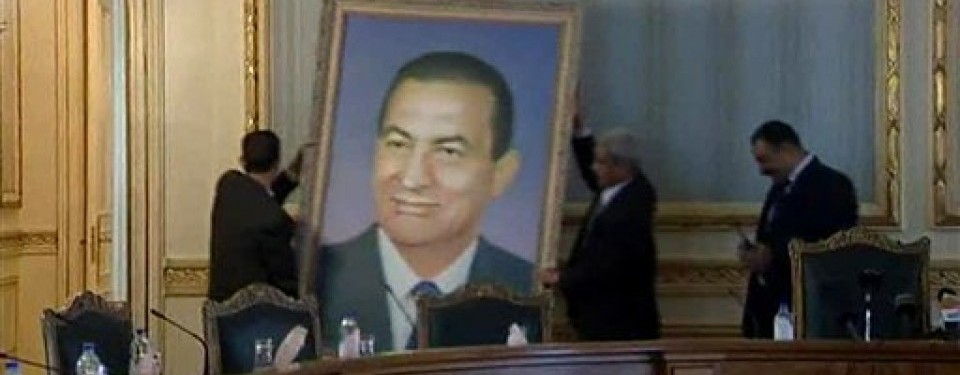 Pegawai menurunkan foto mantan Presiden Mesir, Hosni Mubarak, dari ruang utama kabinet.