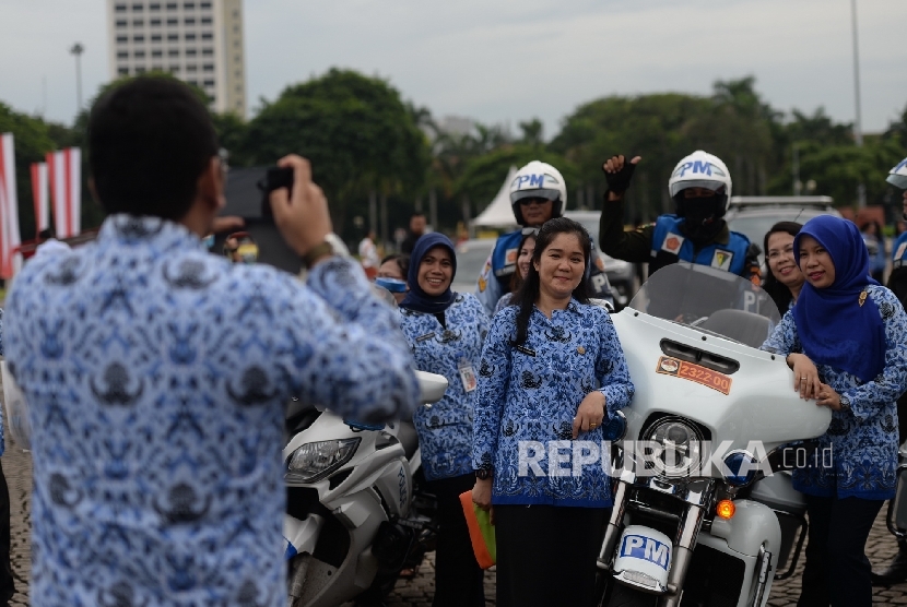 Pegawai negeri sipil melakuka swafoto usai mengikuti upacara peringatan Hari Ulang Tahun ke-45 KORPRI di Lapangan Monumen Nasional, Jakarta, Selasa (29/11)