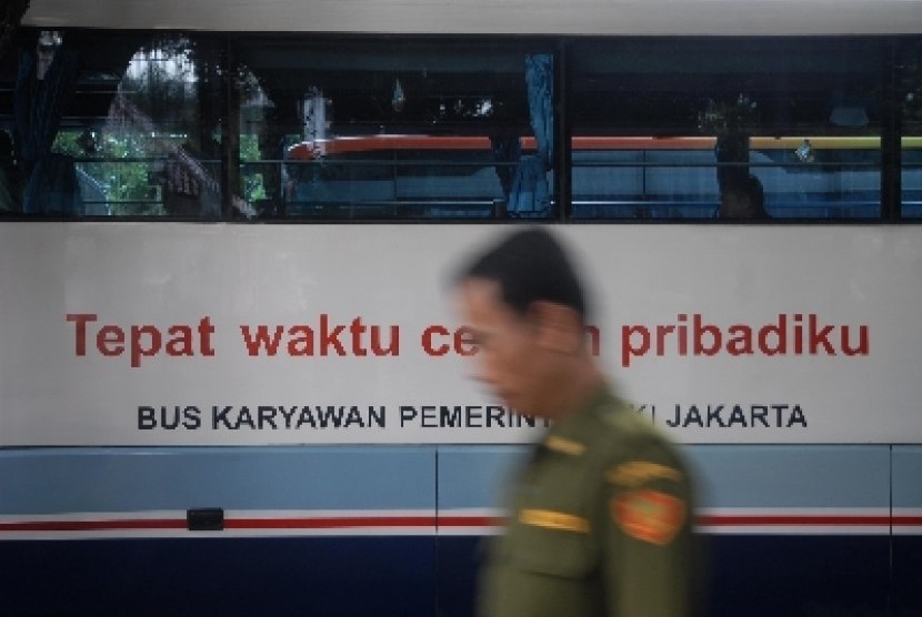 Pegawai Negeri Sipil melintasi armada bus Pemrov DKI di Balaikota, Jakarta Pusat