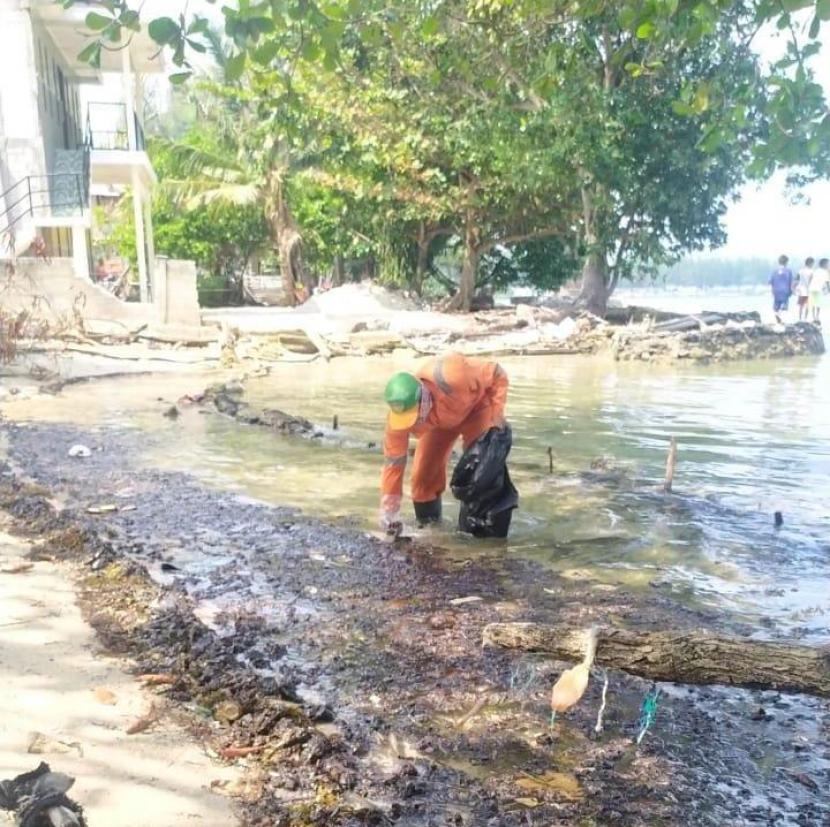 Pegawai PPSU ikut membersihkan tumpahan minyak di perairan Kepulauan Seribu, Selasa (11/8).