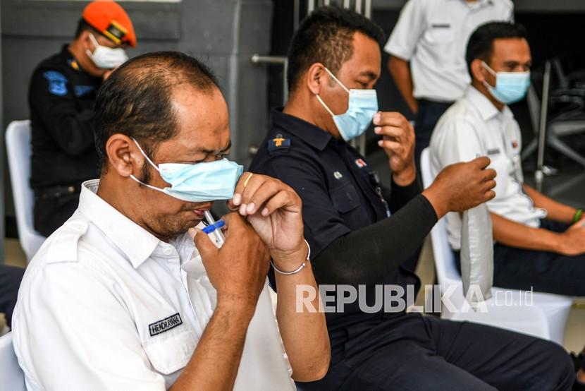 Pegawai PT KAI (persero) menghembuskan nafasnya pada kantong nafas untuk dites dengan GeNose C19 di Stasiun Pasar Senen.