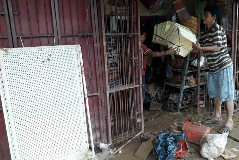 Pegawai Sany Parsel di Jl Jatinegara Barat sudah mulai membersihkan tokonya yang terendam banjir pada saat malam tahun baru. 