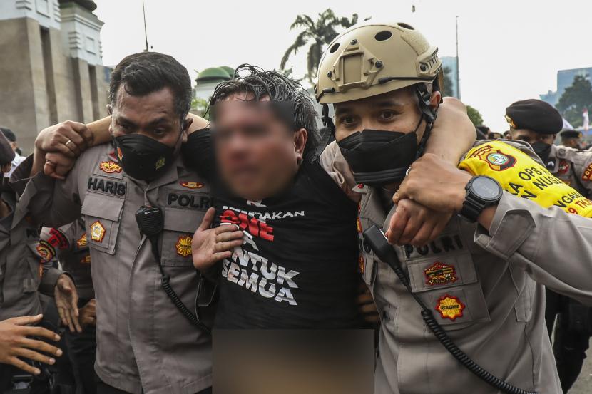 Ade Armando (tengah) diamankan petugas kepolisian saat dikeroyok massa pada Senin (11/4/2022), lalu.
