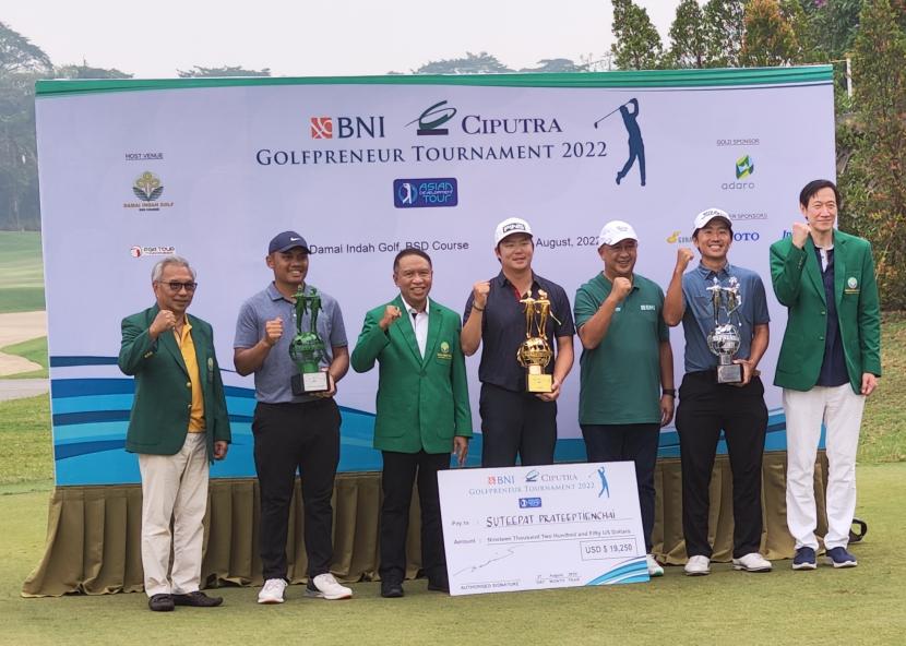 Pegolf asal Thailand, Suteepat Prateeptienchai (tengah) menggenggam trofi juara BNI Ciputra Golfpreneur Tournament ADT 2022 di Damai Indah Golf-BSD Course, Banten, Sabtu (27/8/2022).