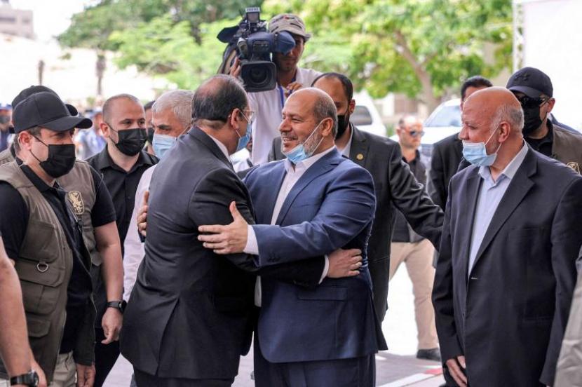 Pejabat Hamas Khalil al-Hayya (tengah-kanas) memeluk Jenderal Abbas Kamel (tengah-kiri), kepala intelijen Mesir, ketika yang terakhir tiba untuk pertemuan dengan para pemimpin Hamas di Kota Gaza pada 31 Mei 2021 