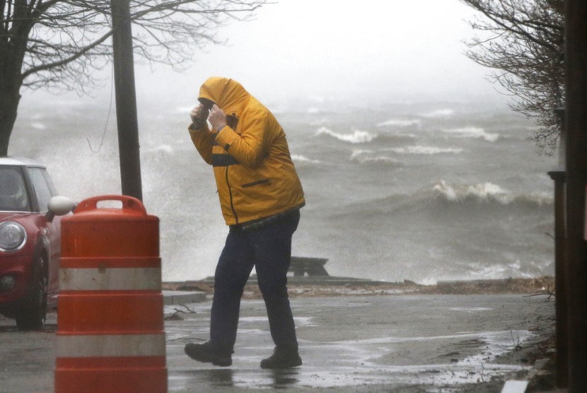 Pejalan kaki berjalan di dekat garis pantai di Newburyport, Massachusetts, Pantai Timur AS di tengah badai, Jumat (2/3). Cuaca buruk yang menerjang AS menyebabkan kekacauan transportasi.