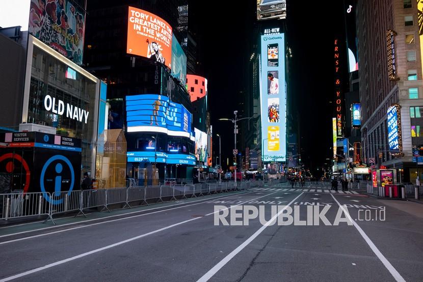 Pejalan kaki berjalan di Times Square yang hampir kosong menjelang Malam Tahun Baru, (ilustrasii).