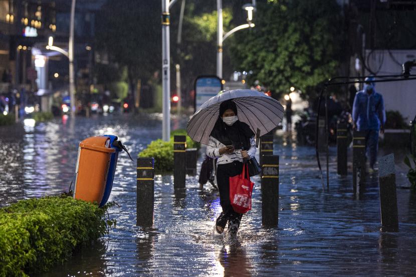 Pejalan kaki berjalan melewati banjir yang menggenangi Jalan Kemang Raya, Jakarta Selatan, Senin (20/12/2021). Hujan deras yang mengguyur sebagian Jakarta membuat sejumlah wilayah di Ibu Kota terendam banjir. 