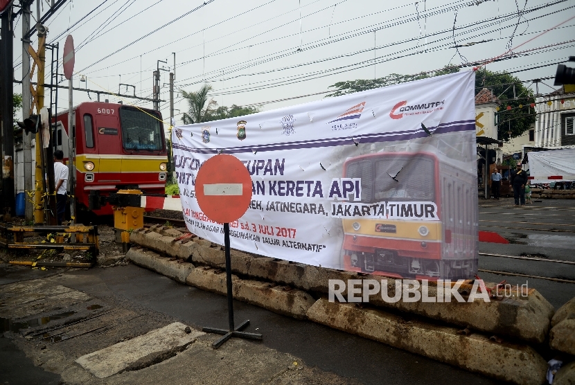 Pejalan kaki melintas di dekat spanduk uji coba penutupan pintu perlintasan kereta di Pisangan Baru, Jakarta (Ilustrasi)