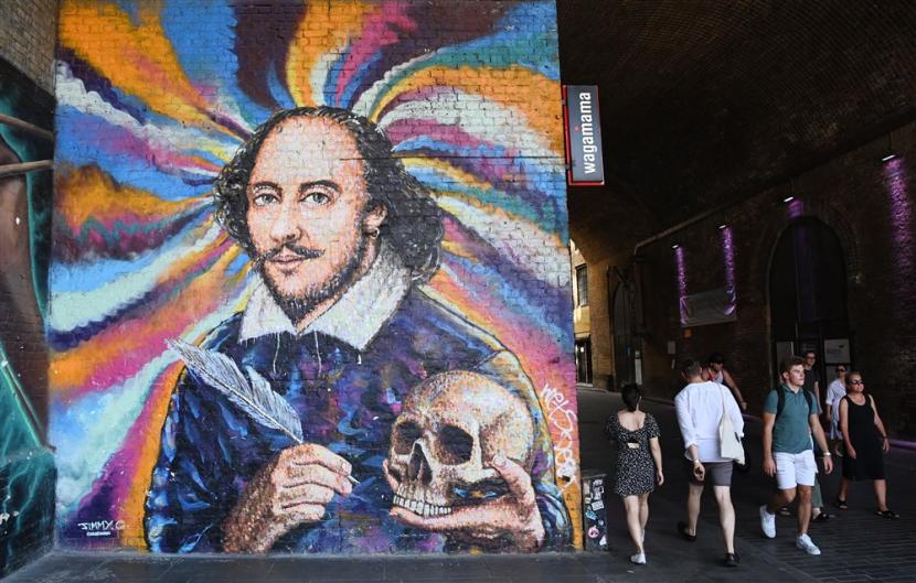 Pejalan kaki melintas melewati sebuah mural yang menggambarkan penyair William Shakespeare di London, Inggris, 31 Juli 2020. Kisah hidup Shakespeare akan diangkat menjadi serial drama.