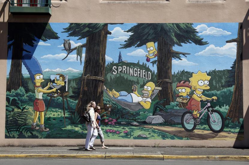 Pejalan kaki melintasi mural kreasi Old City Artists yang memperlihatkan keluarga The Simpsons di Springfield, Oregon, AS, 24 Juli 2022. Musim 34 sitkom animasi itu akan tayang pada September 2022.