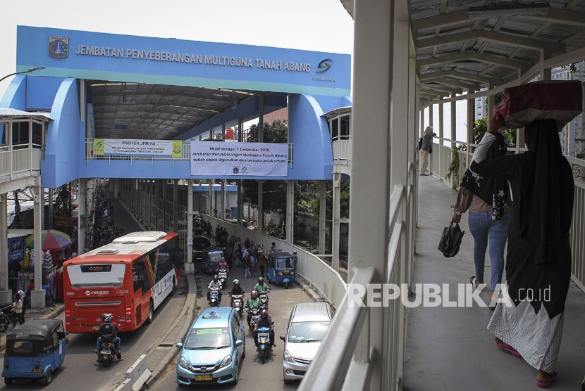 Pejalan kaki melintasi Skybridge atau Jembatan Penyeberangan Multiguna (JPM) Tanah Abang di Jakarta, Jumat (7/12/2018). 