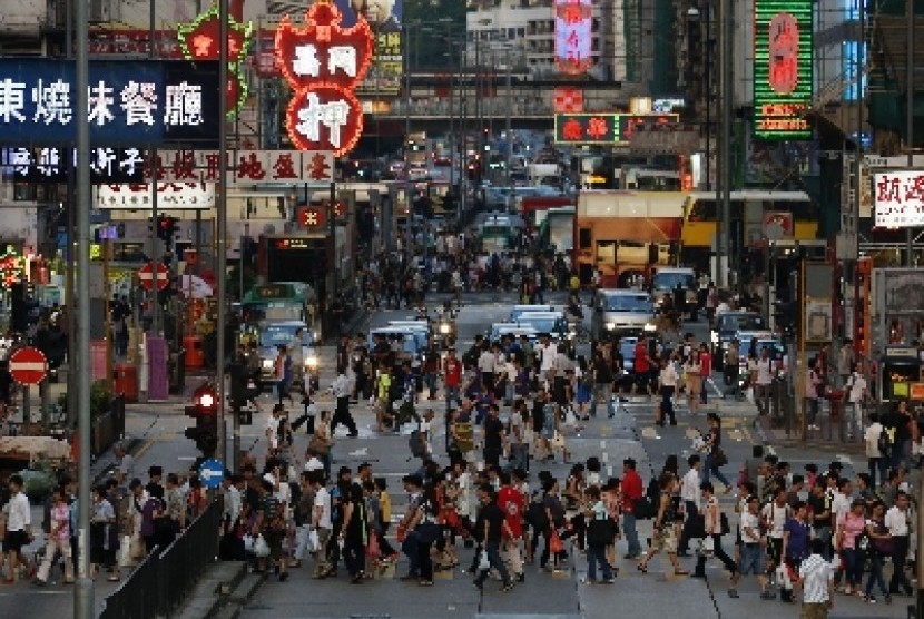 Pejalan kaki memenuhi jalanan di kawasan belanja Mongkok di Hong Kong.