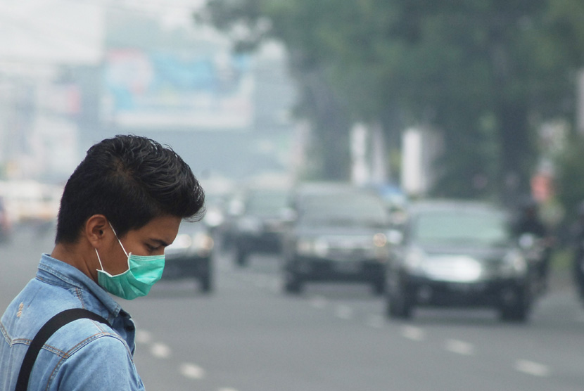 Pejalan kaki menggunakan masker saat melintas di Jalan Pemuda, Padang, Sumbar, Rabu (26/2).