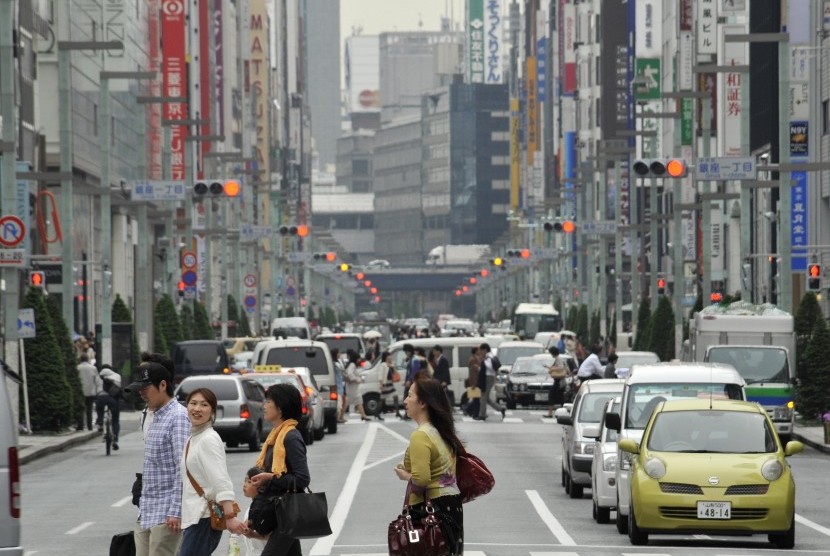 Pejalan kaki menyeberang di distrik perbelanjaan mewah di Ginza, Jepang.
