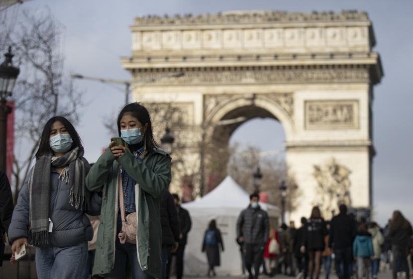 Pejalan kaki yang mengenakan masker berjalan di Champs-Elysees di pusat kota Paris, Prancis, 30 Desember 2021. Menteri Kesehatan Prancis Brigitte Bourguignon mengatakan pada Senin (27/6/2022), warga Prancis harus mulai mengenakan masker lagi di tempat-tempat ramai, terutama di transportasi umum. 