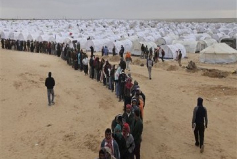 Pekerja asing di Libya mengantri makanan di kamp pengungsian di perbatasan dengan Tunisia, Selasa (8/3).