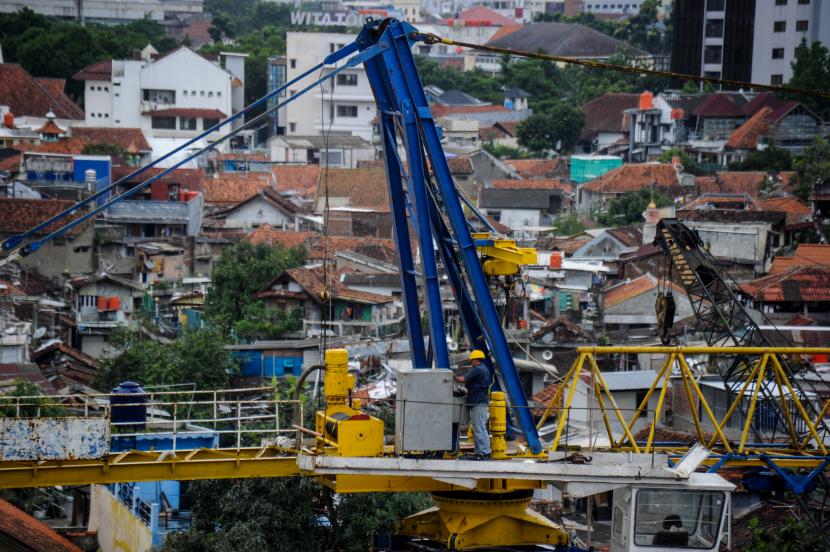 Pekerja beraktivitas di atas crane proyek pembangunan rumah deret, Tamansari, Bandung, Jawa Barat.