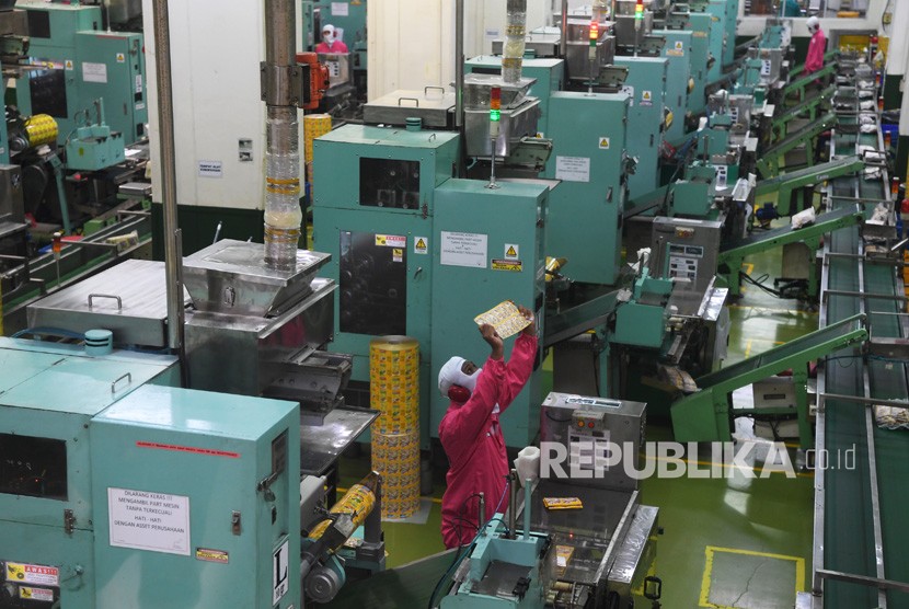Pekerja beraktivitas di dalam pabrik pengelolahan bahan baku