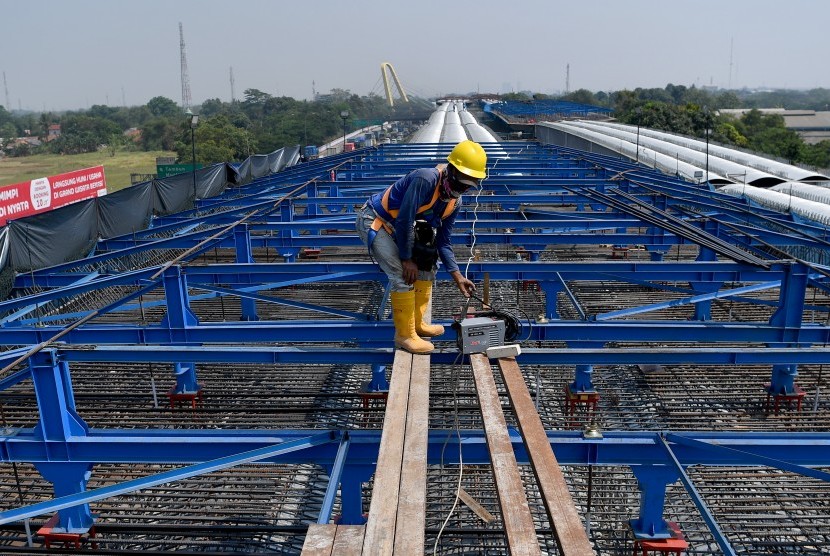 Pekerja beraktivitas di proyek pembangunan konstruksi jalan tol layang Jakarta-Cikampek (Japek) II di Bekasi, Jawa Barat, Jumat (27/7).