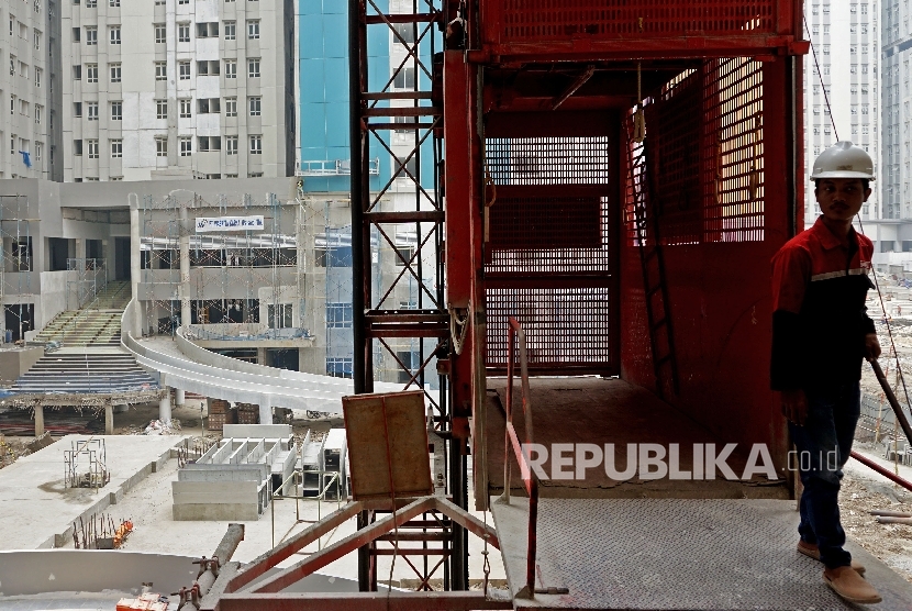 Pekerja beraktivitas disekitar proyek pembangunan rusun wisma atlet Kemayoran, Jakarta, Rabu (19/7).