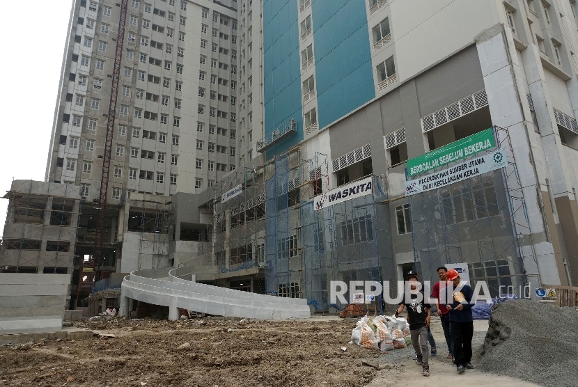 Pekerja beraktivitas disekitar proyek pembangunan rusun wisma atlet Kemayoran, Jakarta, Rabu (19/7).