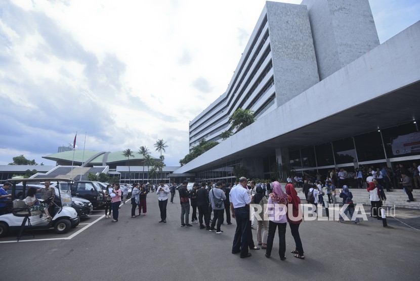 Pekerja berhamburan keluar Gedung Nusantara III saat merasakan gempa di Kompleks Parlemen, Senayan, Jakarta, Selasa (23/1).