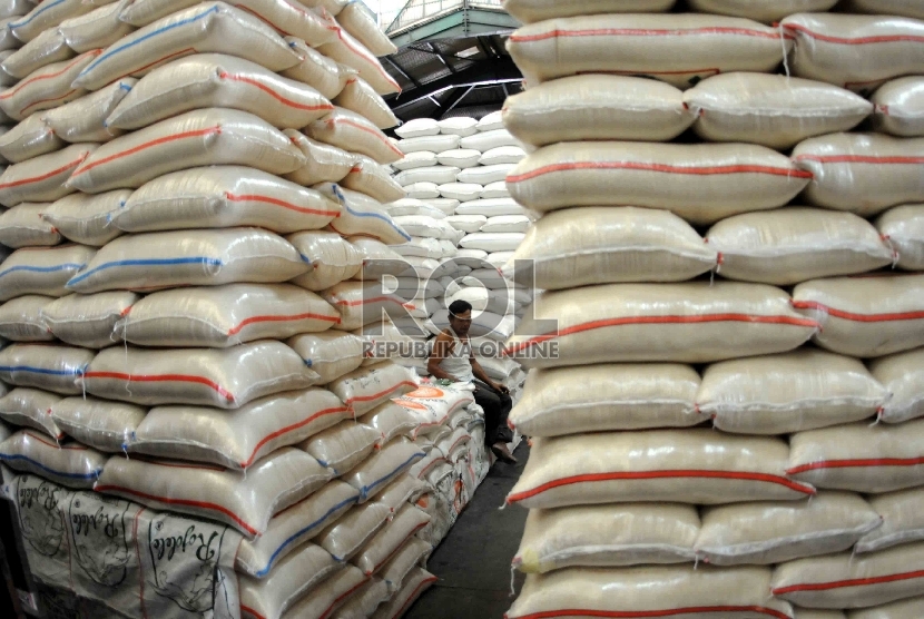  Pekerja beristirahat ditengah tumpukan karung beras di Pasar Induk Cipinang, Jakarta, Kamis (15/10).