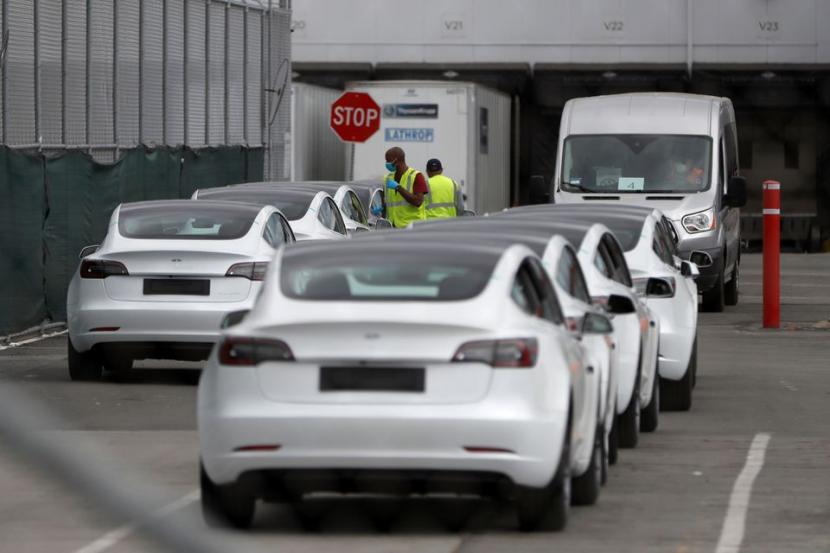 Pekerja berjalan di antara deretan kendaraan listrik Tesla Model 3 di pabrik kendaraan utama Tesla setelah CEO Elon Musk mengumumkan dia menentang pembatasan penyakit virus corona (COVID-19) pejabat lokal dengan membuka kembali pabrik di Fremont, California, AS, 11 Mei 2020. Foto ilustrasi.