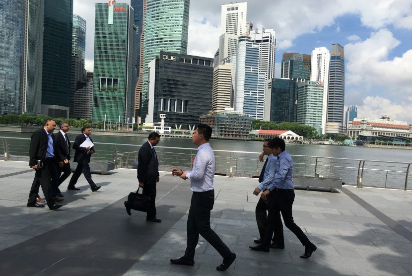 Pekerja berjalan di kawasan distrik finansial Marina Bays Singapura. Kawasan pusat bisnis (CBD) di Singapura rentan tenggelam oleh air laut yang naik karena dampak pemanasan global.