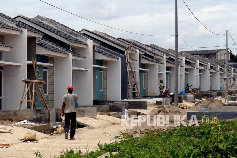 Pekerja berjalan di proyek pembangunan rumah subsidi di kawasan Citeureup, Kabupaten Bogor, Jawa Barat, Kamis (10/2/2022). Pertumbuhan KPR didukung oleh pemulihan ekonomi sejalan dengan terkendalinya pandemi. Ilustrasi.