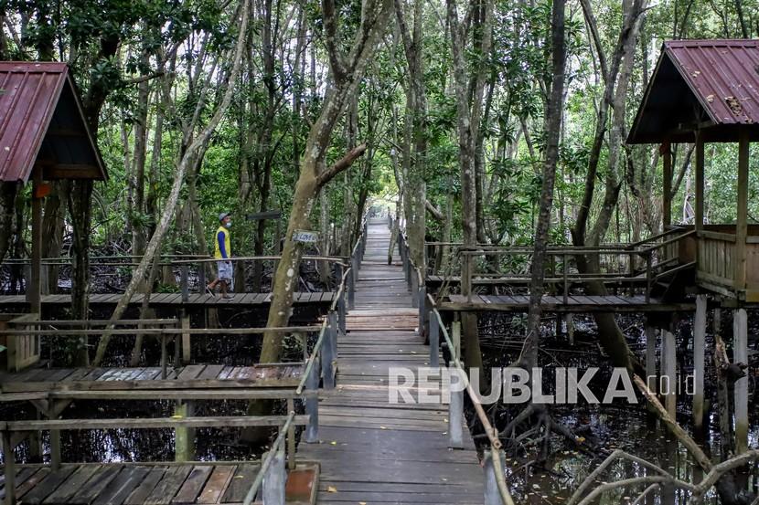 Pekerja berjalan di treking mangrove kawasan wisata mangrove Pandang Tak Jemu ,Batam ,Kepulauan Riau, Rabu (13/10/2021). SE BVK atur ketentuan wisatawan Singapura ke Bintan dan Batam.
