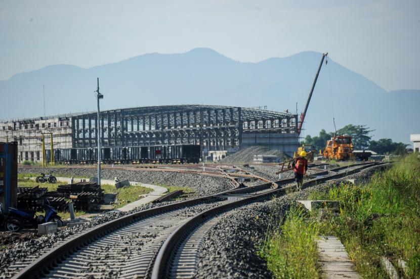 Pekerja berjalan ditengah rel pada proyek pembangunan Stasiun Kereta Cepat Jakarta Bandung di Tegalluar, Kabupaten Bandung, Jawa Barat, Senin (18/7/2022). Pemasangan rel terakhir kereta cepat Jakarta-Bandung (KCJB) saat ini sudah selesai dilakukan pada 20 Maret 2023.