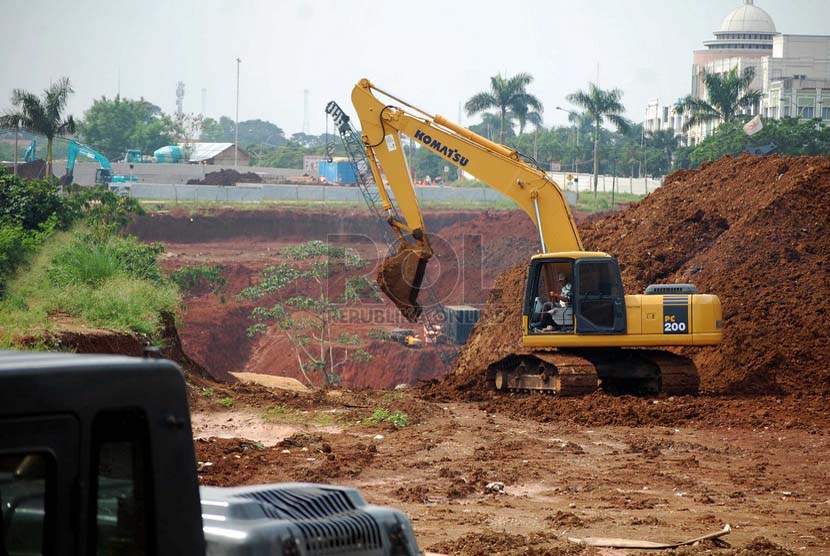 Pekerja dan sebuah alat berat kembali menyelesaikan pembangunan tunnel underpass tol Cijago di Jalan Margonda Raya, Depok, Jumat (27/6).