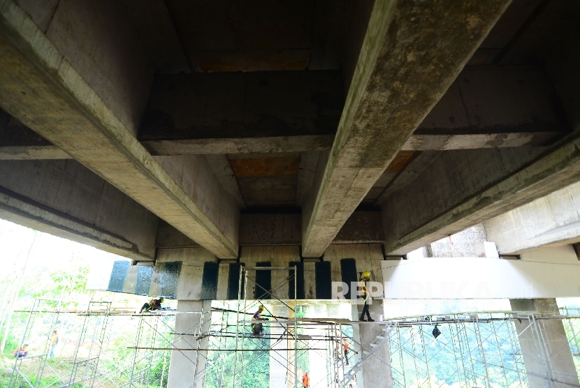   Pekerja dari Jasa Marga memperbaiki retakan pada pilar jembatan Cisomang Jalan Tol Pubaleunyi KM 100 akibat pergeseran, perbatasan Kabupaten Bandung Barat dan Kabupaten Purwakarta, Jumat (23/12). 