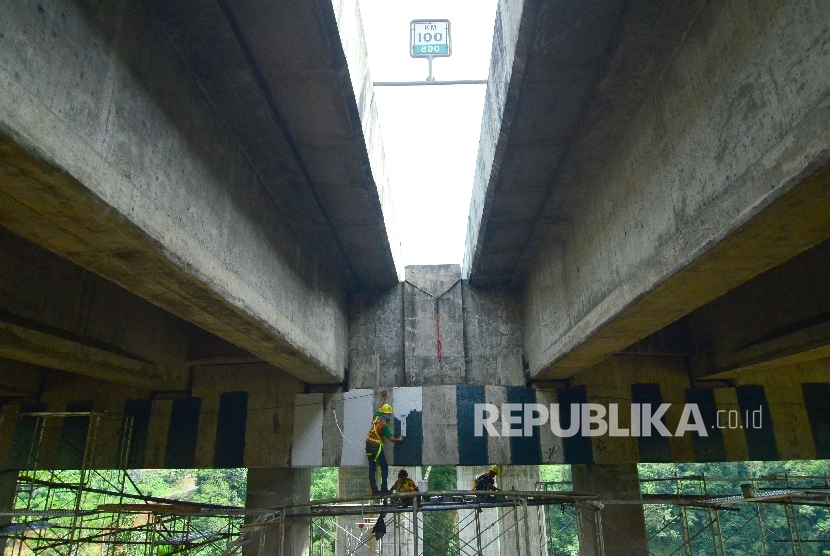 Pekerja dari Jasa Marga memperbaiki retakan pada pilar jembatan Cisomang Jalan Tol Pubaleunyi KM 100 akibat pergeseran, perbatasan Kabupaten Bandung Barat dan Kabupaten Purwakarta, Jumat (23/12).