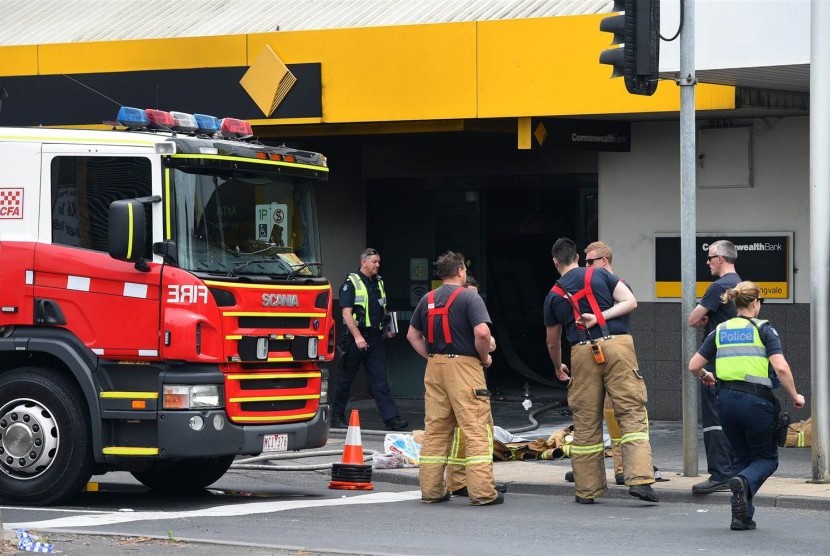 Pekerja darurat berada kantor cabang Commonwealth Bank of Australia, Melbourne dimana seorang pria membakar dirinya, Jumat (18/11). 