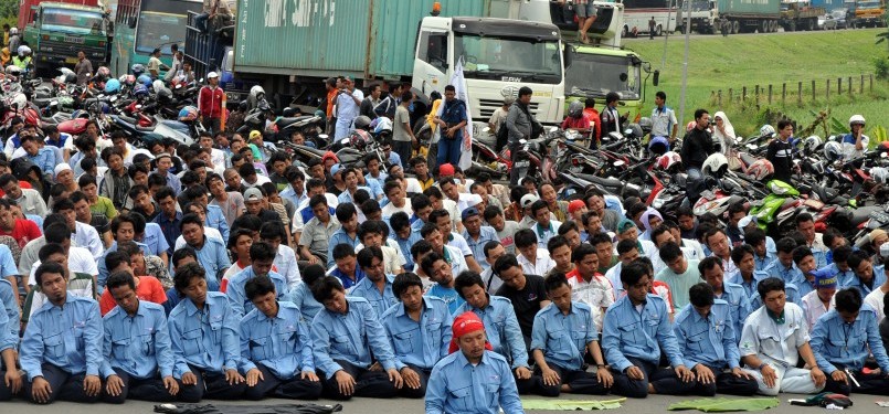 Pekerja demonstrasi melakukan aksi blokir jalan tol Jakarta-Cikampek, Cibitung, Jawa Barat, Jumat (27/1).  (Republika/Tahta Adilla)