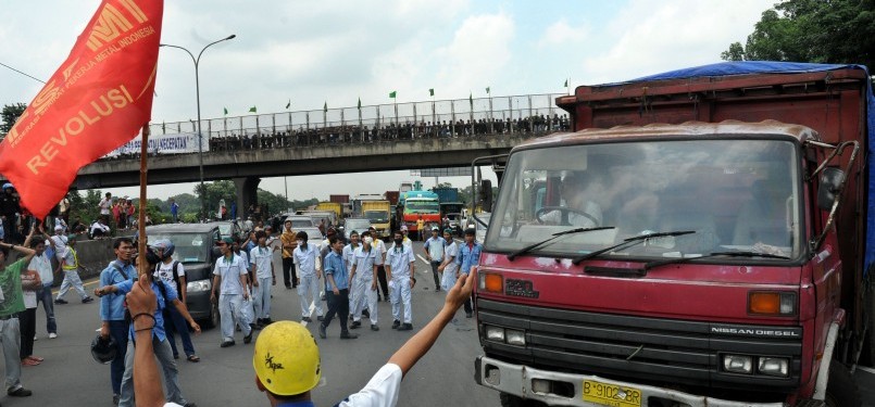 Pekerja demonstrasi melakukan aksi blokir jalan tol Jakarta-Cikampek, Cibitung, Jawa Barat, Jumat (27/1).  (Republika/Tahta Aidilla)