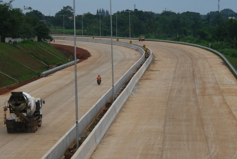 Pekerja dengan mengendarai kendaraan melintas di proyek pembangunan ruas tol Cinere - Cengkareng atau Tol Jakarta Outer Ring Road II (JORR II) sesi ruas Serpong - Kunciran di Serpong, Tangerang Selatan, Banten.