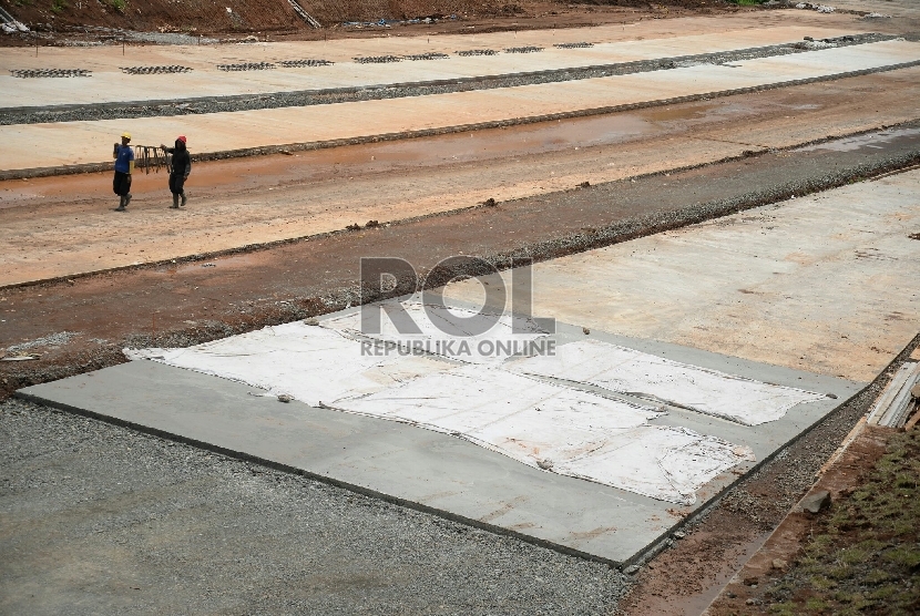 Pekerja dibantu alat berat menyelesaikan pembangunan proyek Tol Cijago, di Jalan Juanda, Depok, Jawa Barat, Senin(9/3). 