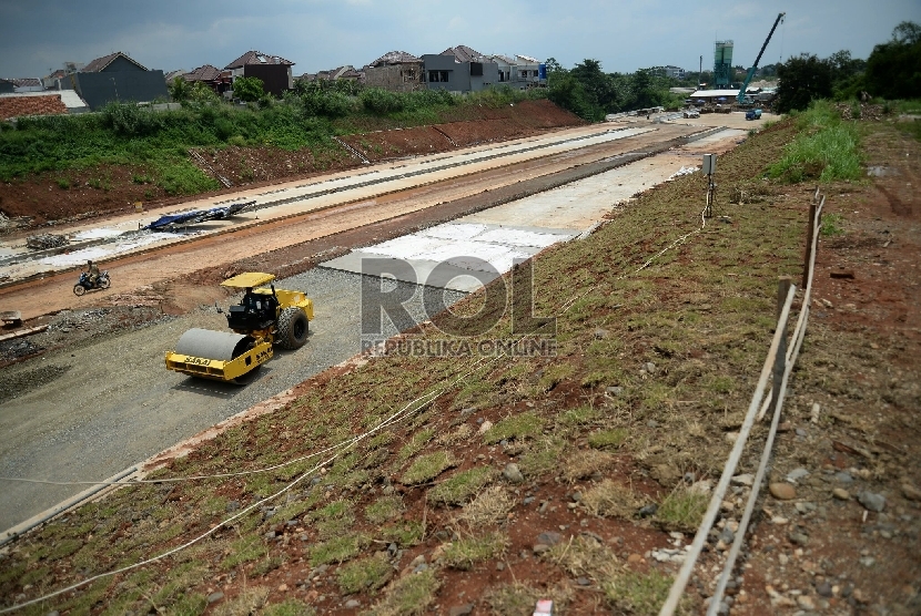 Pekerja dibantu alat berat menyelesaikan pembangunan proyek Tol Cijago, di Jalan Juanda, Depok, Jawa Barat, Senin(9/3). 